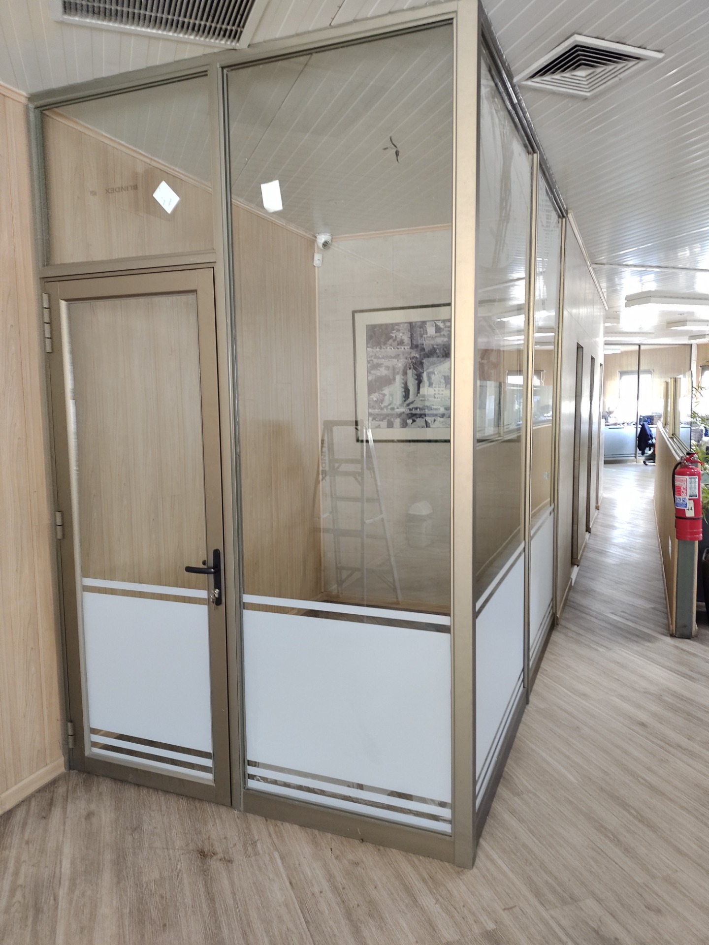 División de oficina con aluminio y vidrio laminado, adicional una lámina esmerilada